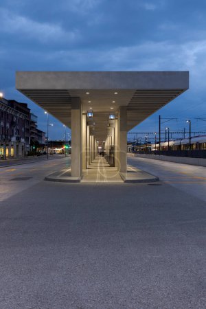 Photo for Modern bus stop shelter in Mendrisio. There is a long, lighted corridor with several stops. Modern infrastructure in Switzerland. Front view, no one inside. - Royalty Free Image