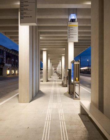 Téléchargez les photos : Arrêt de bus moderne à Mendrisio. Il y a un long couloir lumineux avec plusieurs arrêts. Infrastructures modernes en Suisse. Vue de face, personne à l'intérieur. - en image libre de droit