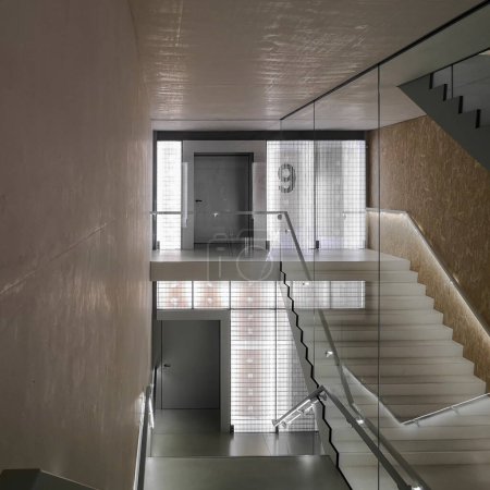 Téléchargez les photos : Espace avec escalier dans un immeuble ancien mais rénové avec de grandes fenêtres. Personne dans le coin - en image libre de droit