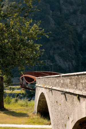 Téléchargez les photos : Détail d'un pont piéton et vélo rouillé moderne avec une partie ancienne du pont. À côté du pont se trouve une grande pelouse verte pour une pause détente. Personne à l'intérieur - en image libre de droit