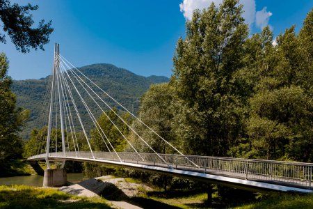 Téléchargez les photos : Pont piétonnier moderne au milieu des montagnes de la Suisse italienne, vous permettant de traverser le Tessin. Belle journée ensoleillée d'été. - en image libre de droit