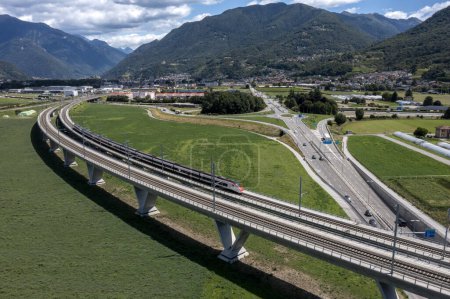 Téléchargez les photos : Passage de pont ferroviaire et d'autoroute, construction suisse et projet au Tessin. Tourné avec un drone, jour avec des nuages. - en image libre de droit