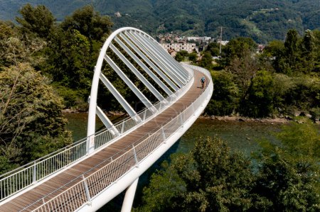 Téléchargez les photos : Pont piétonnier au-dessus d'une petite rivière suisse, le Tessin. En été, la passerelle est en pleine nature avec une forme très moderne - en image libre de droit