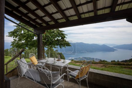 Téléchargez les photos : Vue depuis une terrasse à Cardada sur le lac Majeur, une table prête pour une pause café - en image libre de droit