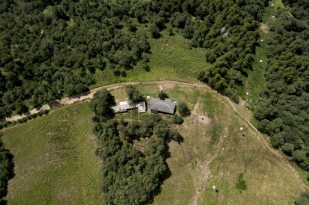 Foto de Vista aérea de una casa con un techo de hojalata en medio de la naturaleza. Bosque y prado alrededor. Estamos en Suiza - Imagen libre de derechos