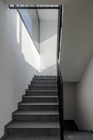 Téléchargez les photos : Vue de face d'un escalier en pierre moderne à l'intérieur d'un immeuble d'appartements nouvellement construit. Personne à l'intérieur - en image libre de droit