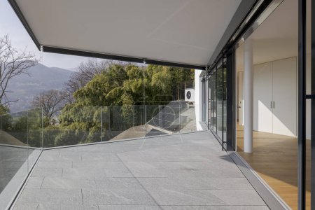 Foto de Amplia terraza de un nuevo piso moderno con vistas a la naturaleza. El piso está hecho de piedra. - Imagen libre de derechos