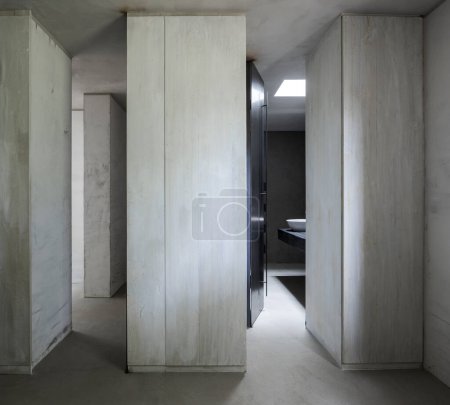 Téléchargez les photos : Vue de face d'un mur avec un couloir et une porte ouverte sur une salle de bain minimaliste moderne. Personne à l'intérieur - en image libre de droit