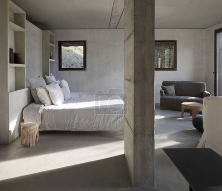 Téléchargez les photos : Chambre moderne d'une ferme design avec un lit double avec beaucoup d'oreillers et de grandes fenêtres qui laissent entrer beaucoup de lumière naturelle. Personne à l'intérieur - en image libre de droit