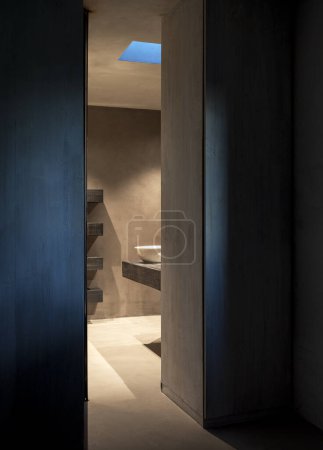 Téléchargez les photos : Vue sur une salle de bain contemporaine avec un lavabo blanc et un comptoir et des étagères en bois, présentant une esthétique moderne et minimaliste. Personne à l'intérieur - en image libre de droit