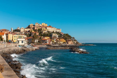Foto de Un hermoso pueblo en Liguria en un promontorio con vistas al mar. Hay rocas y barcos de pesca. Nadie dentro. - Imagen libre de derechos