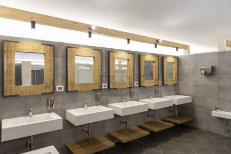 Téléchargez les photos : Salle de bain publique avec cinq lavabos, miroirs et distributeurs de savon. Moderne et simple. Personne à l'intérieur - en image libre de droit