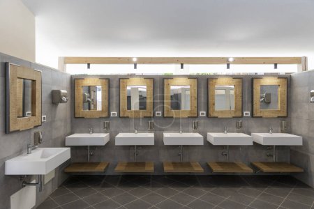 Téléchargez les photos : Salle de bain publique avec cinq lavabos, miroirs et distributeurs de savon. Moderne et simple. Personne à l'intérieur - en image libre de droit