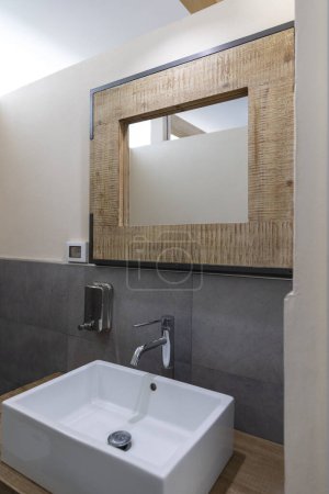 Téléchargez les photos : Détail d'un évier avec un miroir en osier et un distributeur de savon. Personne à l'intérieur - en image libre de droit