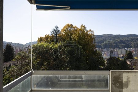 Photo for View from a balcony, green trees and green mountains in the background. Sunny winter day. No one inside. - Royalty Free Image