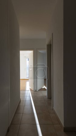 Photo for Hallway with white walls and tiles. There are open doors showing the rooms. Nobody inside - Royalty Free Image