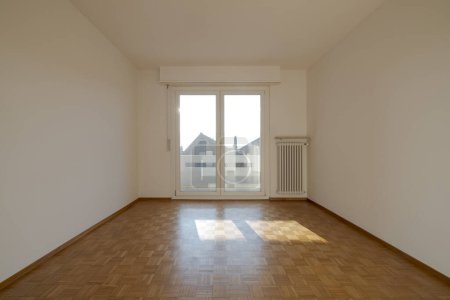 Téléchargez les photos : Intérieur d'une chambre vide, vue de face avec une fenêtre à l'arrière. Grand espace - en image libre de droit