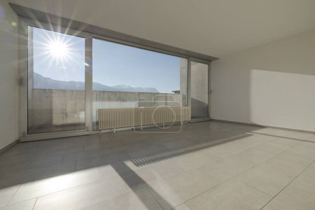 Foto de Gran ventana luminosa con sol directo que entra en la habitación con vistas a las montañas suizas. No hay nadie adentro - Imagen libre de derechos