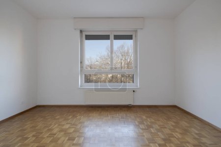 Téléchargez les photos : Vue de face d'une chambre vide avec parquet et vue sur la nature. Personne à l'intérieur - en image libre de droit