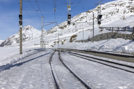 Photo for Train station on the Bernina Pass in Switzerland. Railway switch and tracks appearing from the snow. Nobody inside - Royalty Free Image