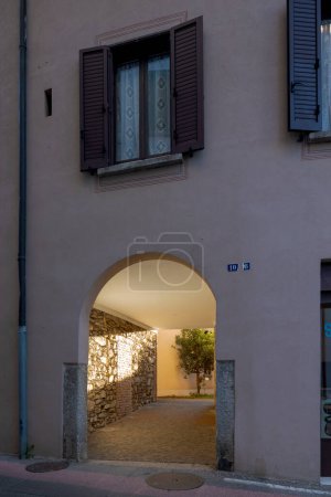 Photo for Arched entrance of an old renovated courtyard house with a beam of light illuminating the entrance corridor. A plant can be seen at the bottom. No one inside - Royalty Free Image