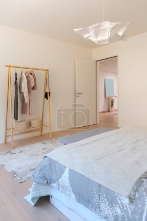 Photo for Detail or glimpse of a bedroom interior. One can see the exit and the clothes hanger. The door is open. - Royalty Free Image