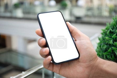 Foto de Teléfono de mano masculino con pantalla aislada tienda de fondo en cente comercial - Imagen libre de derechos