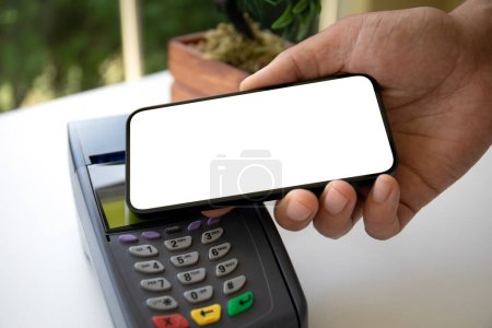 Photo for Man payment purchase for phone with isolated screen and pay pass online terminal in cafe - Royalty Free Image