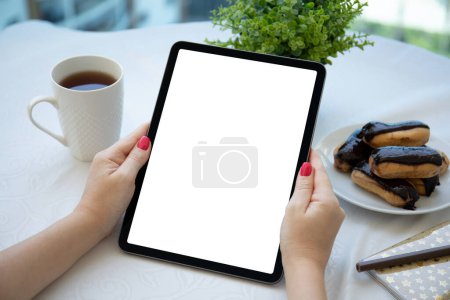 Foto de Tableta de computadora de mano femenina con mesa de fondo de pantalla aislada en café - Imagen libre de derechos