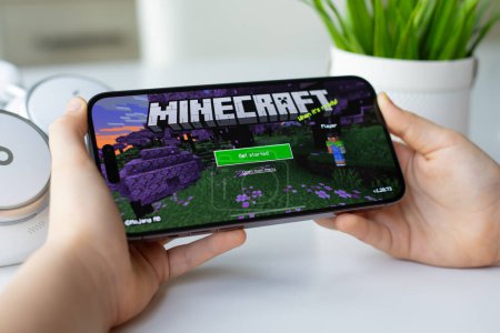 Photo for Alanya, Turkey - April 11, 2024: Children hands holding Apple iPhone 15 Pro Max with multiplayer online game Minecraft mobile in the screen IOS phone. Games Minecraft was created by the Mojang Studios. - Royalty Free Image