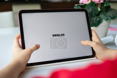 Photo for Alanya, Turkey - April 11, 2024: Children hands holding Apple iPad Air with multiplayer online game Roblox mobile in the screen IOS tablet. Games Roblox was created by the Roblox Corporation. - Royalty Free Image