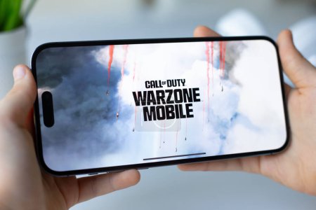 Photo for Alanya, Turkey - April 13, 2024: Children hands holding phone Apple iPhone 15 Pro Max with game Call of Duty Mobile in the screen. Games Call of Duty was created by the Activision Publishing, inc. - Royalty Free Image