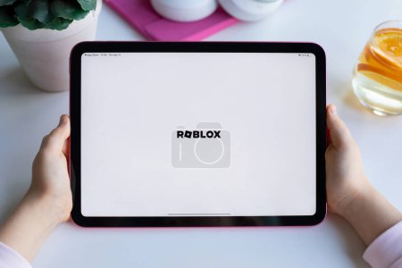 Photo for Alanya, Turkey - April 13, 2024: Children hands holding Apple iPad Air with multiplayer online game Roblox mobile in the screen IOS tablet. Games Roblox was created by the Roblox Corporation - Royalty Free Image