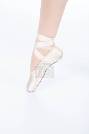 En Pointe INCORRECT extension closeup teachers perspective Close up of young female ballet dancer showing various classic ballet feet positions for classical ballet or dance against a white background in pink silk and satin pointe shoes