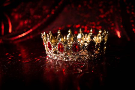 Foto de Corona de lujo con piedras preciosas de rubí sobre fondo de brillo rojo - Imagen libre de derechos
