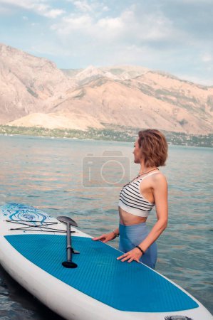 Photo for Woman on sup board. Mountain background. Healthy lifestyle - Royalty Free Image