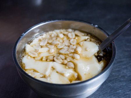 Téléchargez les photos : Pudding au tofu, pudding au soja avec des arachides dans un bol - en image libre de droit