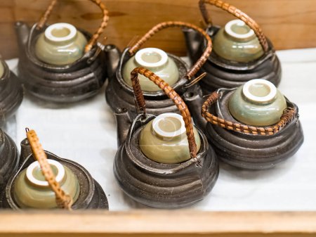 Téléchargez les photos : Dobin mushi (cuisine japonaise) : champignons matsutake cuits à la vapeur et conger de brochet avec bouillon japonais dans une théière en faïence et servi. - en image libre de droit