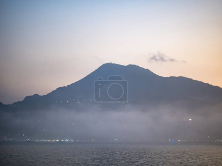 Foto de Mist mountains and river in evening in Tamsui, New Taipei City, Taiwan. - Imagen libre de derechos