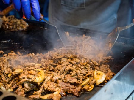 Sizzling Delight : Gros plan sur la viande grillée et les oignons
