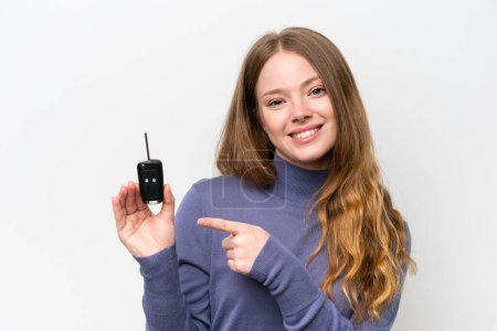 Téléchargez les photos : Jeune femme caucasienne tenant des clés de voiture isolées sur fond blanc et le pointant - en image libre de droit