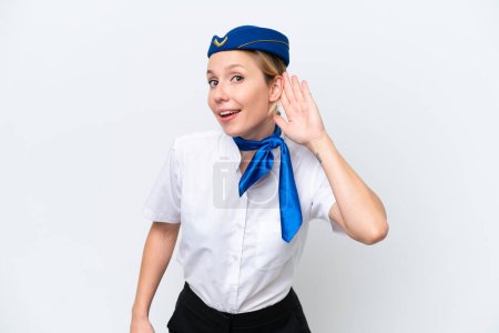 Photo for Airplane blonde stewardess woman isolated on white background listening to something by putting hand on the ear - Royalty Free Image