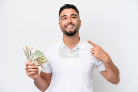 Young Arab man taking a lot of money isolated on white background giving a thumbs up gesture