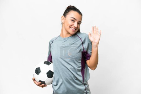 Foto de Joven futbolista Mujer sobre fondo blanco aislado saludando con la mano con expresión feliz - Imagen libre de derechos