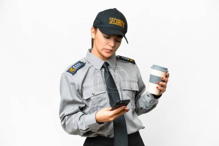 Mujer de salvaguardia joven sobre fondo blanco aislado sosteniendo café para llevar y un móvil