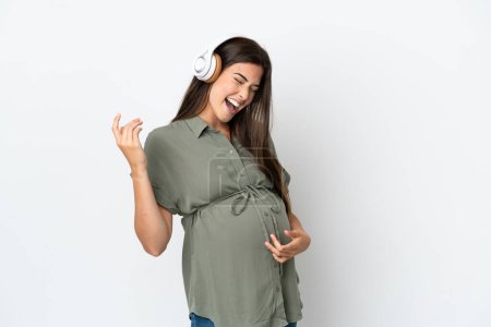 Foto de Mujer brasileña joven aislada sobre fondo blanco embarazada y escuchando música - Imagen libre de derechos