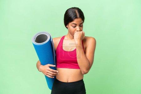 Photo for Young sport African American woman going to yoga classes while holding a mat over isolated background having doubts - Royalty Free Image