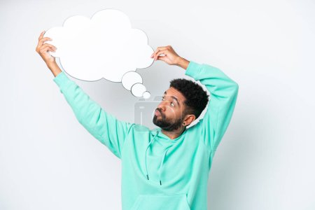 Young Brazilian man isolated on white background holding a thinking speech bubble
