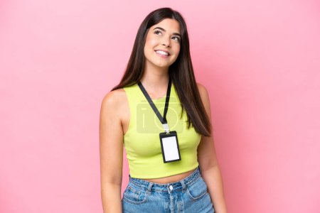 Foto de Young Brazilian woman with ID card isolated on pink background thinking an idea while looking up - Imagen libre de derechos