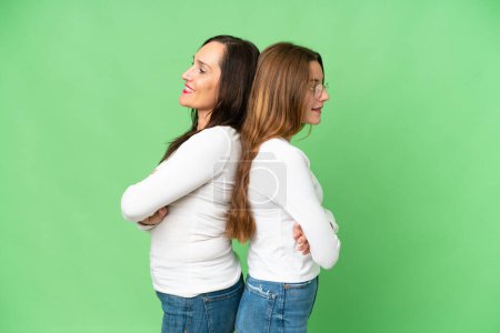 Photo pour Mother and daughter over isolated chroma key background keeping arms crossed - image libre de droit
